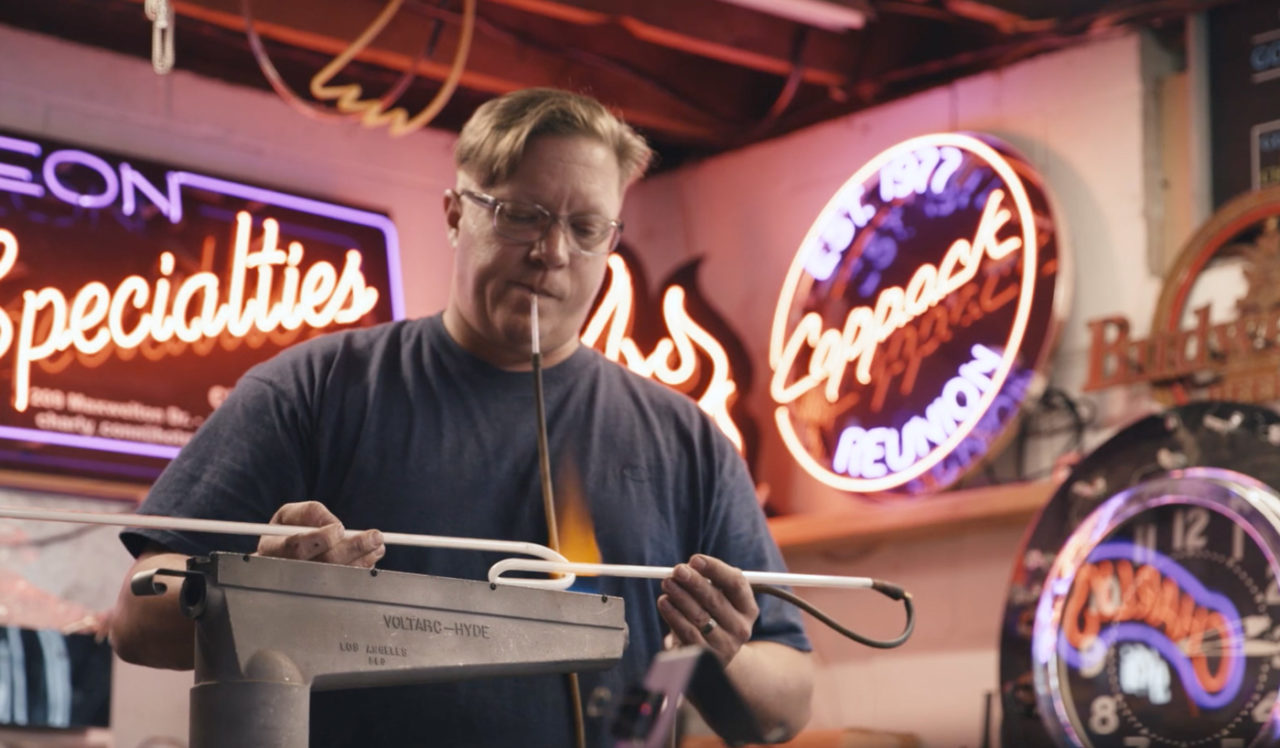 Man creating a sign at Neon Specialities, a collaborator of our Des Moines hotel