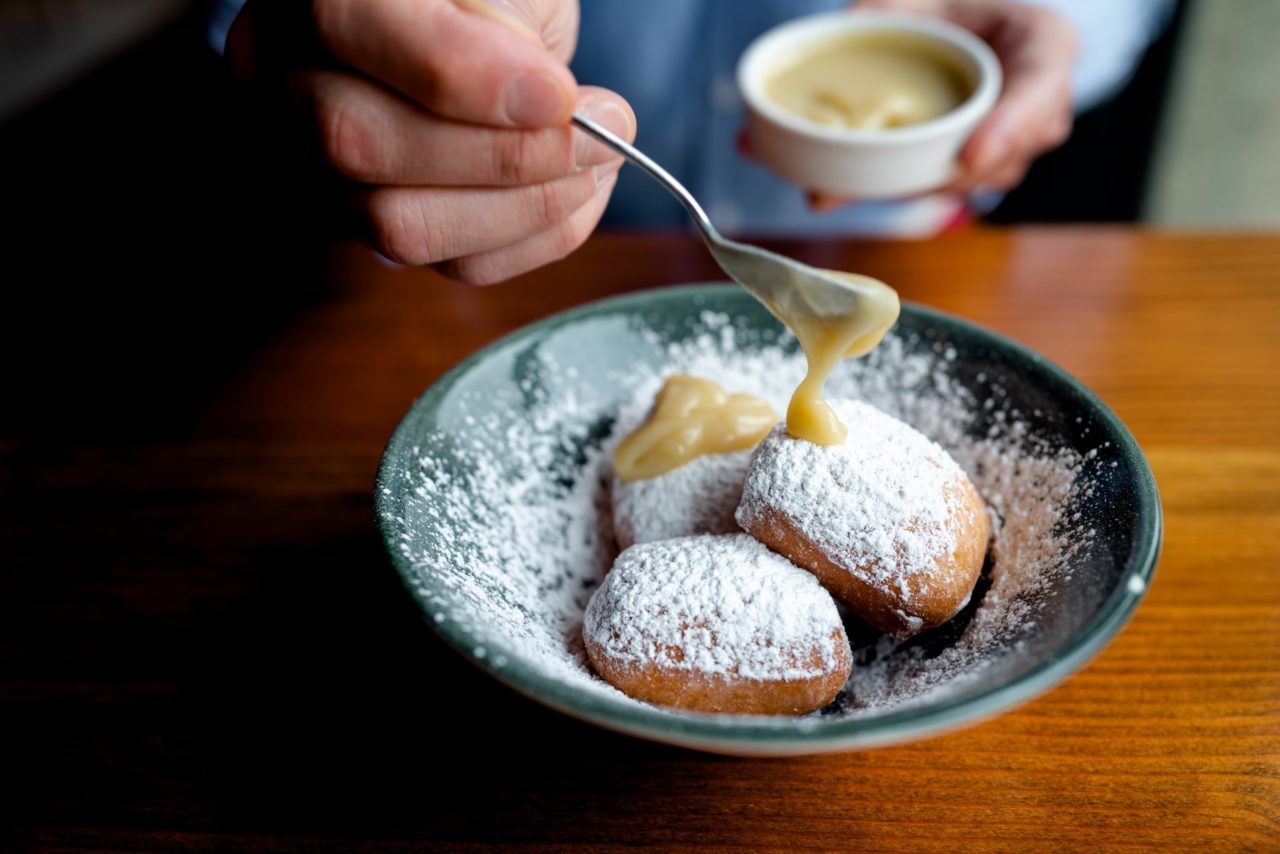 Beignets in a green bowl with powdered sugar at our downtown hotel in Des Moines