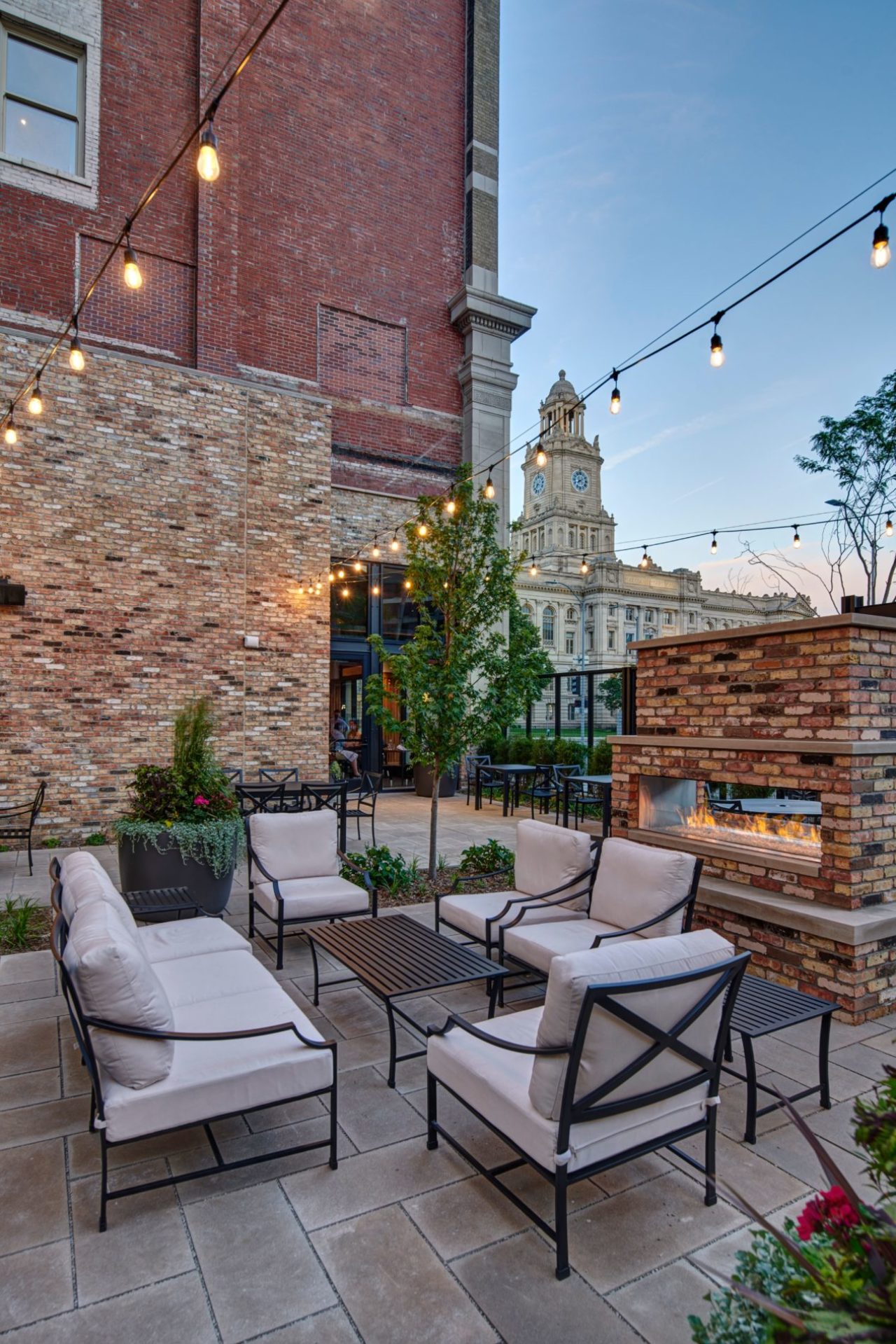 String lights over chairs and an outdoor fireplace at our patio bar in Des Moines