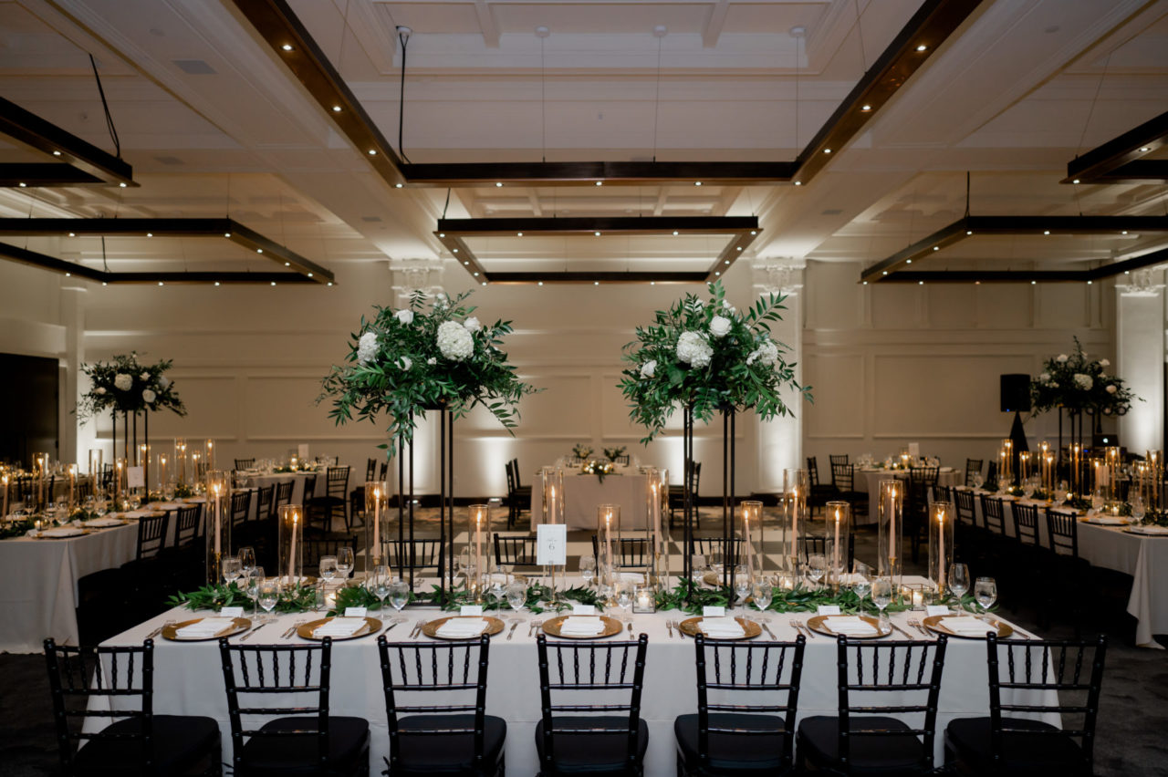 Event tables at our Des Moines hotel with leaves, white flowers, and candles