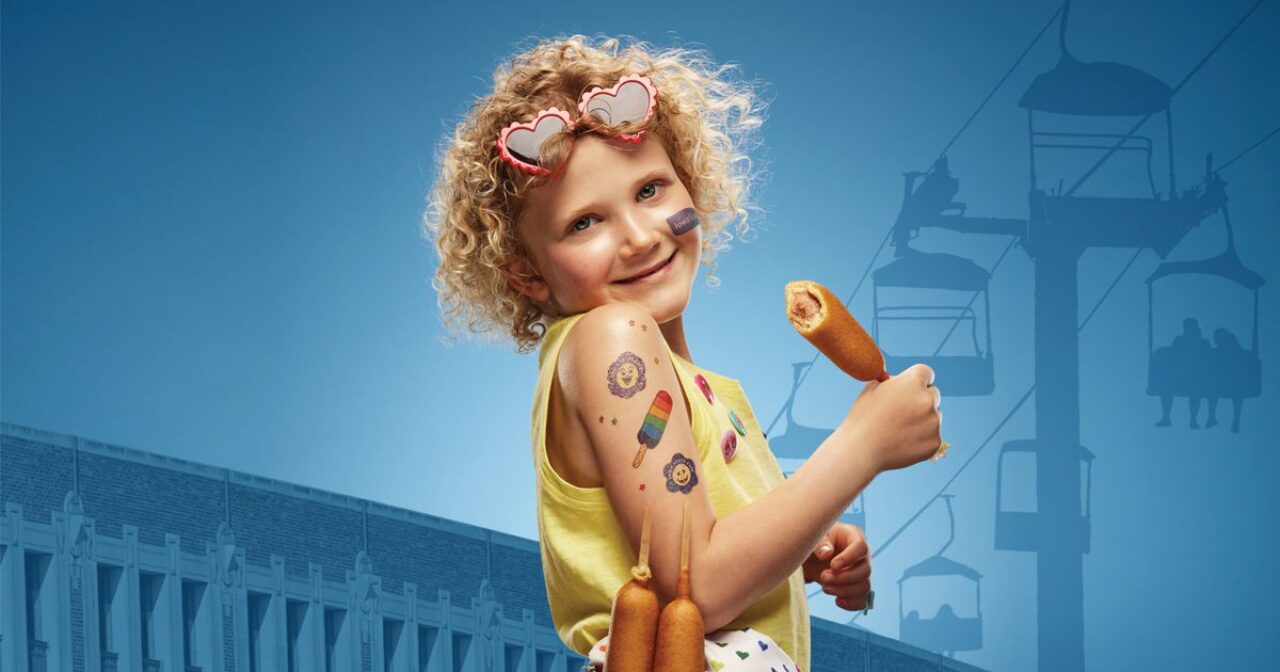 Child with temporary tattoos and a corn dog at the Iowa State Fair